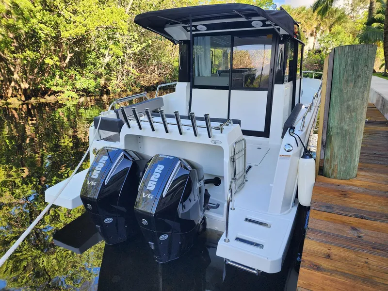 Slide: The Image of 2023 Jeanneau NC Sport 895 boat with dual outboard engines docked by a wooden pier. - 30