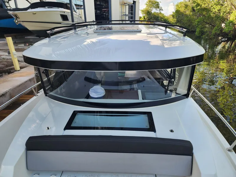 Slide: The Image of 2023 Jeanneau NC Sport 895 boat, sleek design, docked near water and trees. - 6