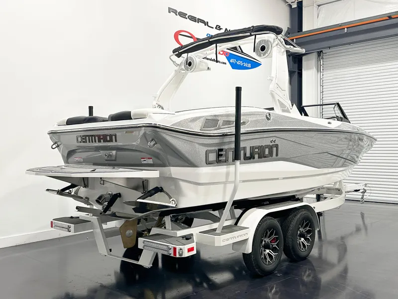 Slide: The Image of 2025 Centurion NV213 boat on trailer in showroom, rear view. - 3