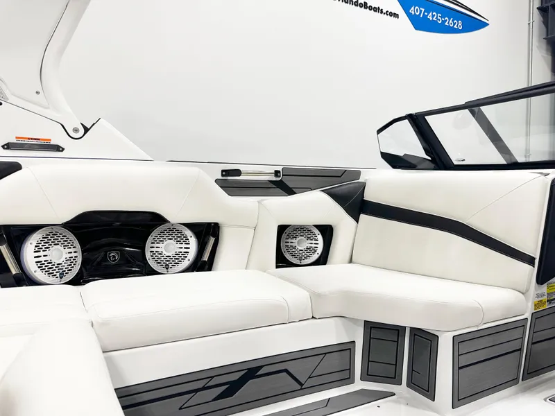Slide: The Image of 2025 Centurion NV213 boat interior with white seating and built-in speakers. - 8