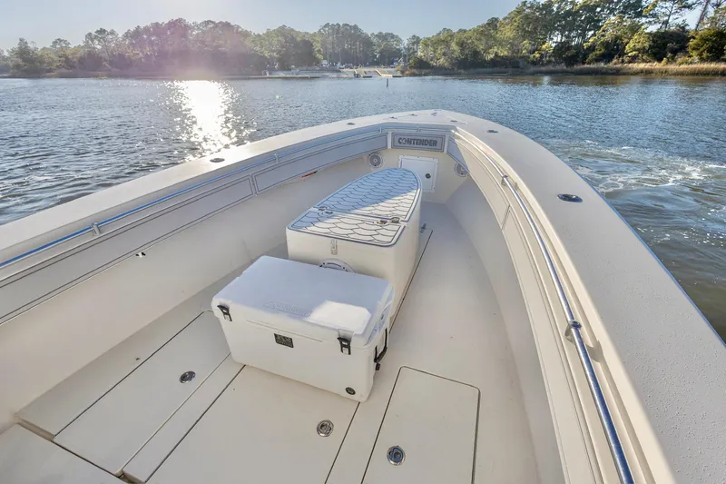 Slide: The Image of 2006 Contender 33T boat on calm water, featuring spacious deck and storage. - 15