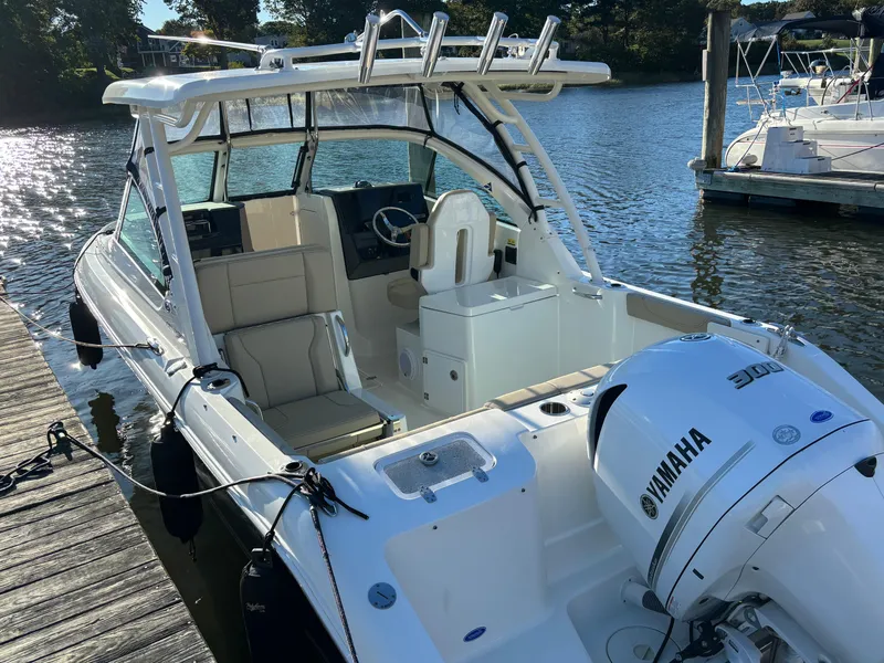 Slide: The Image of 2020 Pursuit DC 235 Dual Console boat docked, featuring Yamaha engine, on a sunny day. - 3