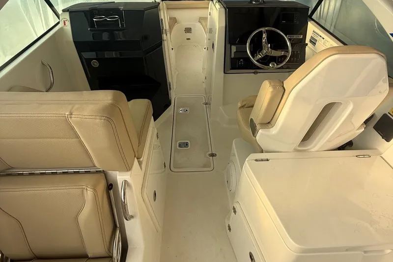 Slide: The Image of 2020 Pursuit DC 235 Dual Console interior with beige seating and modern dashboard. - 4