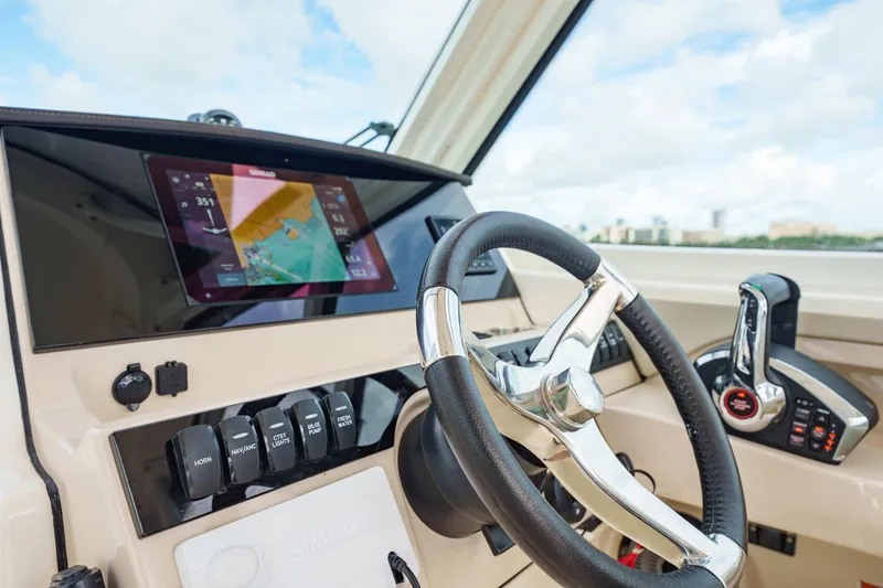 Slide: The Image of 2023 Boston Whaler 280 Vantage helm with steering wheel and navigation display. - 21