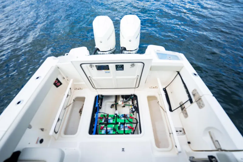 Slide: The Image of 2023 Boston Whaler 280 Vantage boat interior with open engine compartment, dual motors, on water. - 39