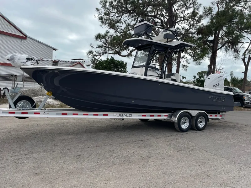 The Image of 2025 Robalo 266 Cayman SD boat on trailer, parked outdoors. - 0