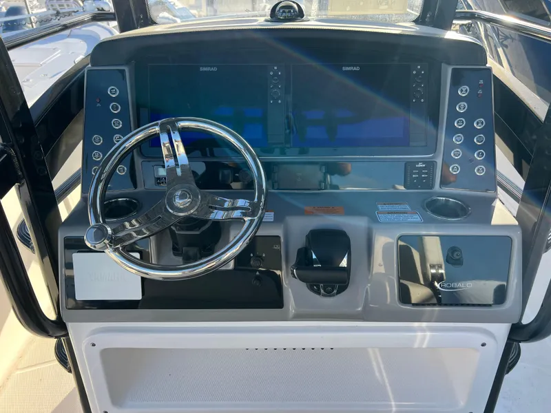 Slide: The Image of 2025 Robalo 266 Cayman SD boat dashboard with dual screens and steering wheel. - 11