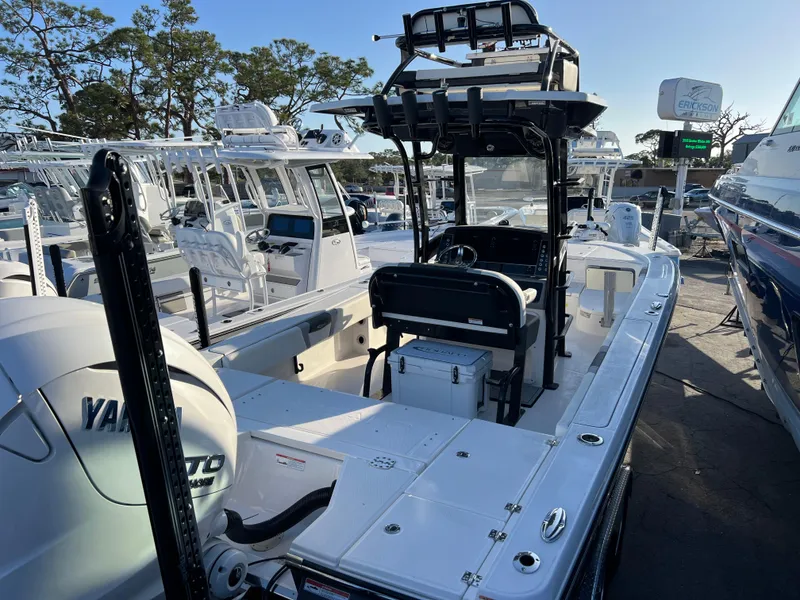 Slide: The Image of 2025 Robalo 266 Cayman SD boat with Yamaha engine, docked among other boats. - 6