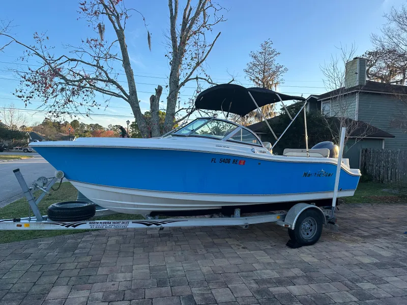 Slide: The Image of 2015 NauticStar 2000 XSDC boat on trailer, blue hull, parked on brick driveway. - 0