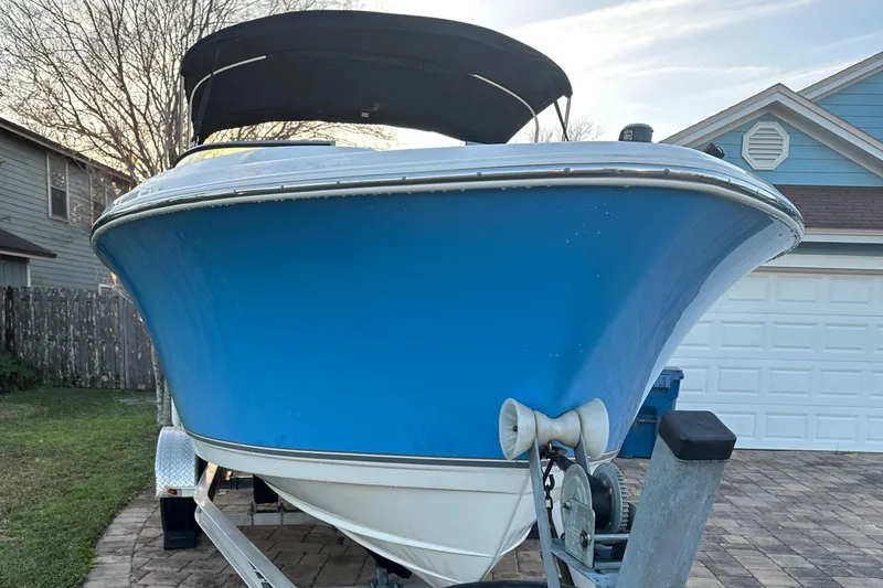 Slide: The Image of 2015 NauticStar 2000 XSDC boat on trailer, blue hull, parked in driveway. - 10