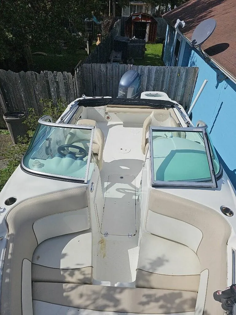 Slide: The Image of 2015 NauticStar 2000 XSDC boat with open deck and seating, parked near a blue building. - 13