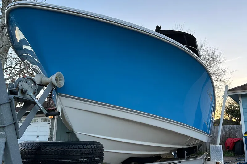 Slide: The Image of 2015 NauticStar 2000 XSDC boat on trailer, blue hull, parked outdoors. - 16
