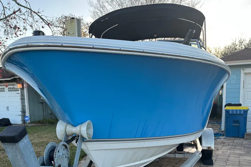 Slide: The Image of 2015 NauticStar 2000 XSDC boat on trailer, blue hull, parked outdoors. - 17