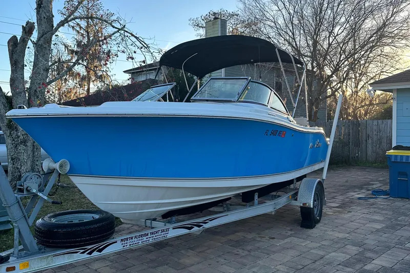Slide: The Image of 2015 NauticStar 2000 XSDC boat on trailer, blue hull, parked outdoors. - 2