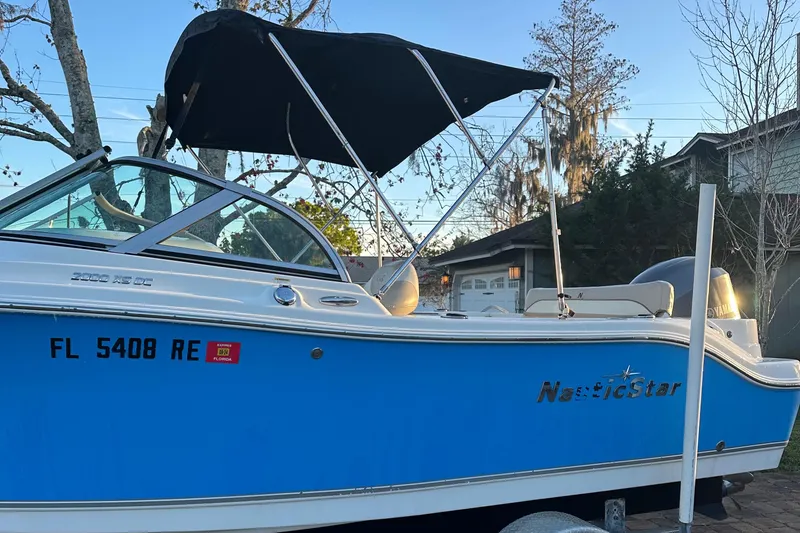 Slide: The Image of 2015 NauticStar 2000 XSDC boat with blue hull and black canopy. - 20