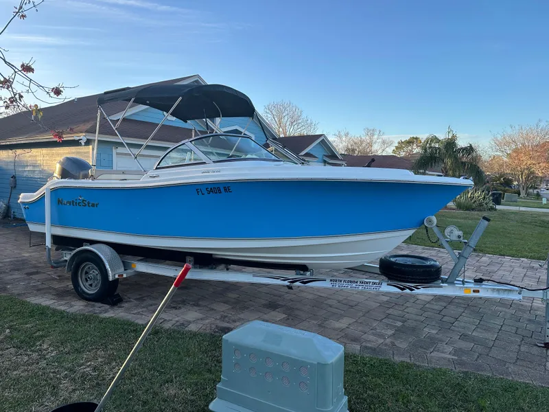 Slide: The Image of 2015 NauticStar 2000 XSDC boat on trailer, parked in residential driveway. - 3