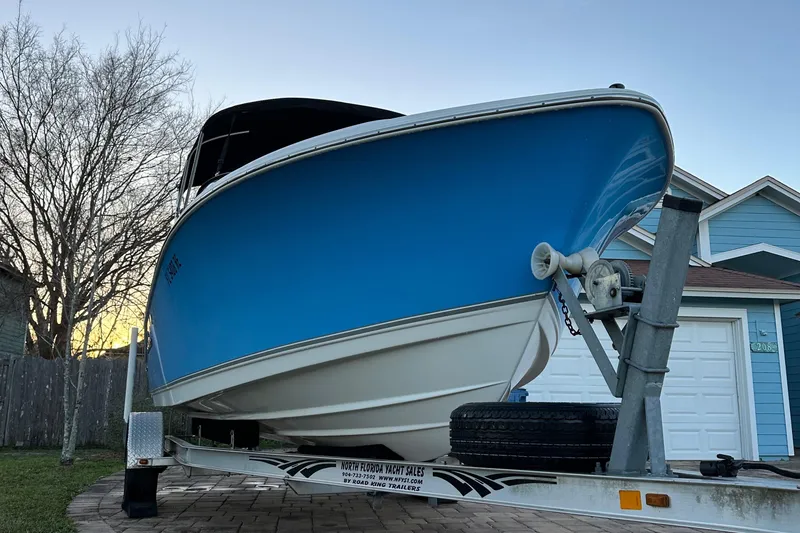 Slide: The Image of 2015 NauticStar 2000 XSDC boat on trailer, blue hull, parked in driveway. - 5