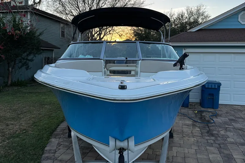 Slide: The Image of 2015 NauticStar 2000 XSDC boat with blue hull, parked on a paved driveway. - 6