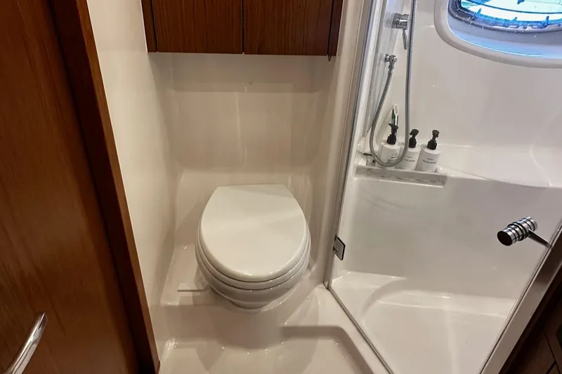 Slide: The Image of 2023 Tiara Yachts 43 Open bathroom with modern fixtures and wooden cabinetry. - 10