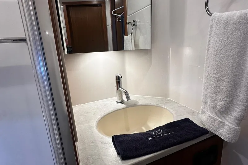 Slide: The Image of 2023 Tiara Yachts 43 Open bathroom sink with towel and modern fixtures. - 12