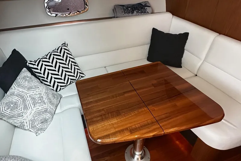 Slide: The Image of 2023 Tiara Yachts 43 Open interior with white seating and wooden table. - 14