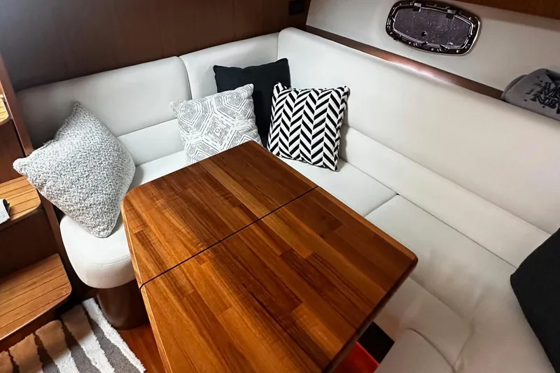 Slide: The Image of 2023 Tiara Yachts 43 Open interior with white seating and wooden table. - 15