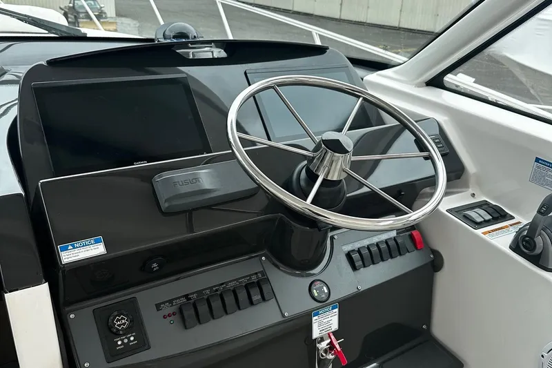 Slide: The Image of 2023 Tiara Yachts 43 Open helm with steering wheel and control panel. - 2