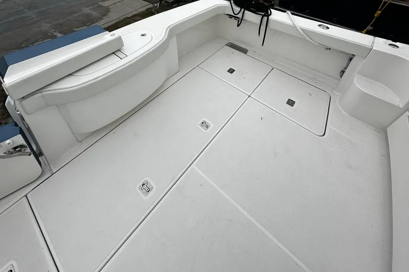 Slide: The Image of 2023 Tiara Yachts 43 Open deck, featuring spacious white flooring and storage compartments. - 26