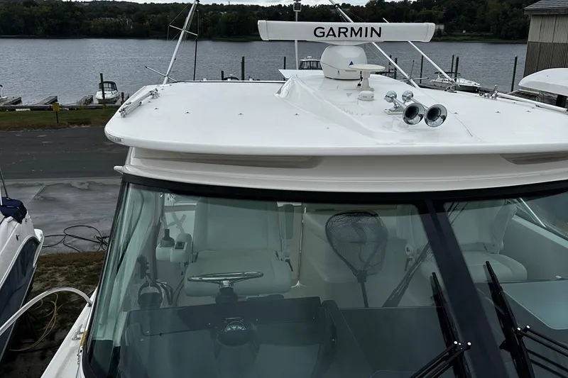 Slide: The Image of 2023 Tiara Yachts 43 Open with Garmin equipment, docked by a serene lakeside. - 32