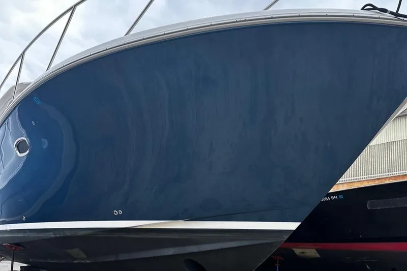 Slide: The Image of 2023 Tiara Yachts 43 Open, blue hull, docked, side view. - 36