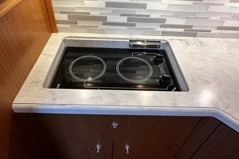 Slide: The Image of 2023 Tiara Yachts 43 Open kitchen with modern stovetop and sleek backsplash design. - 7