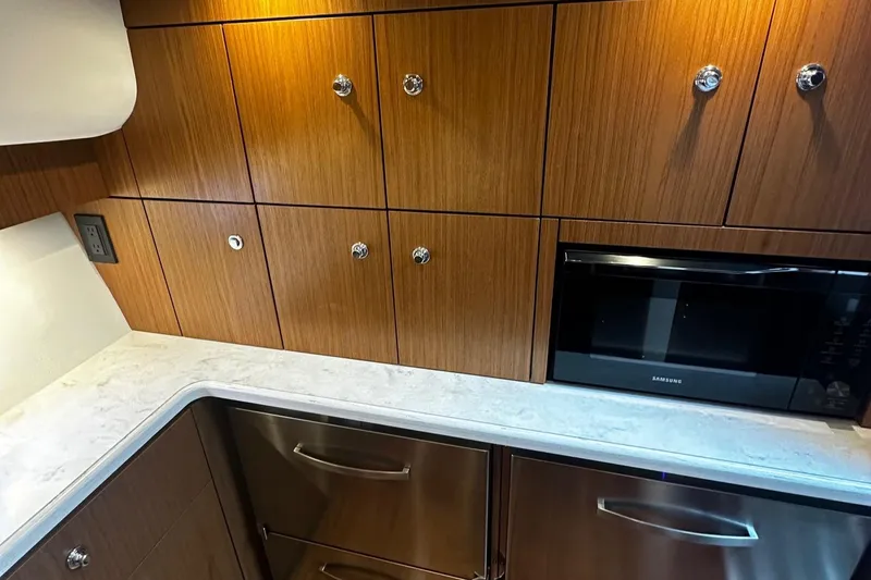 Slide: The Image of 2023 Tiara Yachts 43 Open kitchen with wood cabinets and modern appliances. - 8