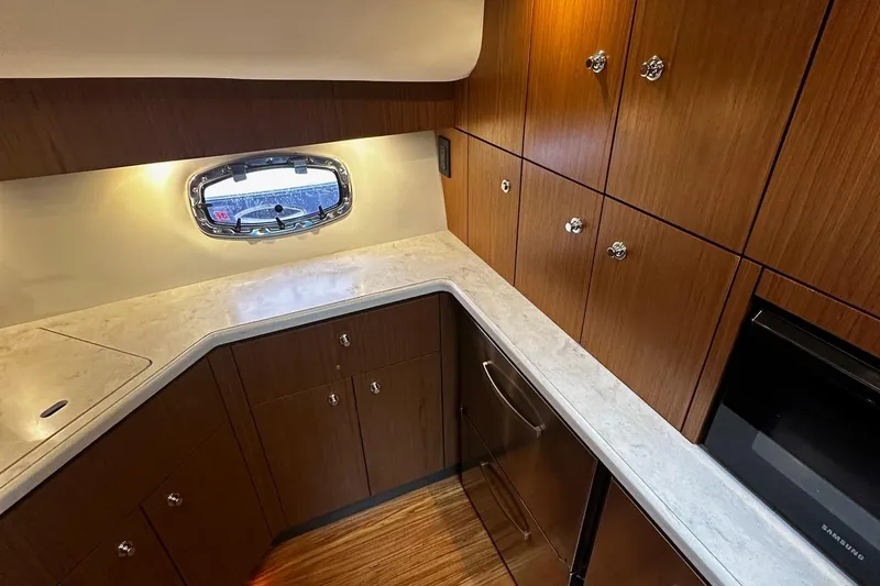 Slide: The Image of 2023 Tiara Yachts 43 Open interior kitchen with wood cabinets and modern appliances. - 9