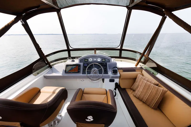 Slide: The Image of 2016 Beneteau Swift Trawler 44 helm with ocean view, featuring modern navigation equipment and seating. - 36