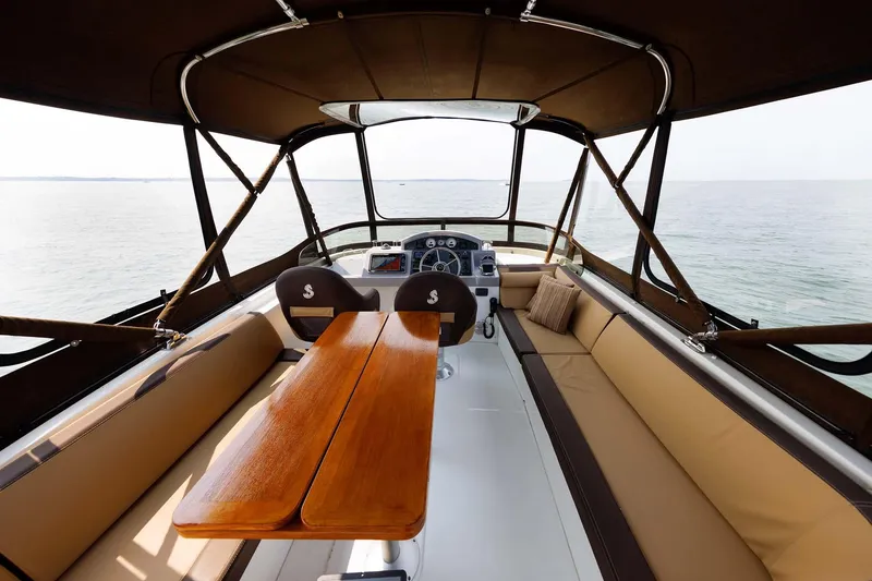 Slide: The Image of 2016 Beneteau Swift Trawler 44 interior with seating and helm, overlooking the water. - 38