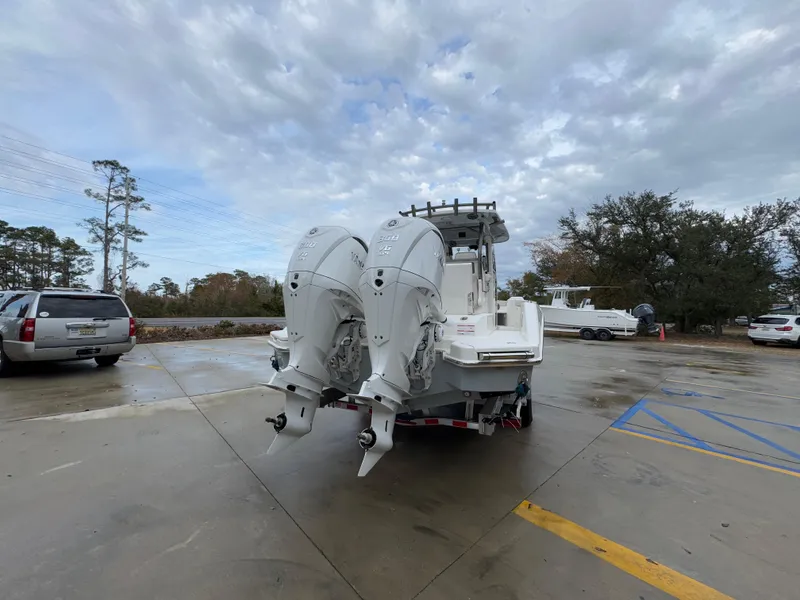 Slide: The Image of 2025 Solace 28 HCS boat with dual outboard engines in a parking lot. - 17