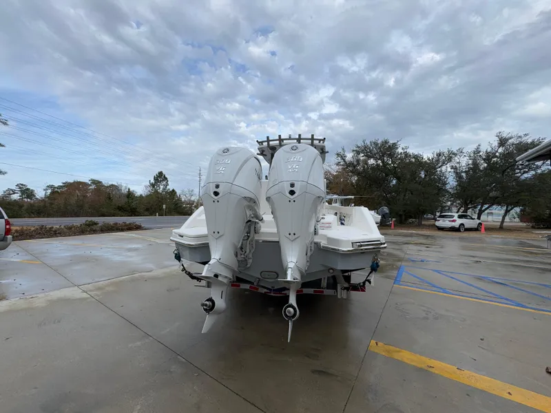 Slide: The Image of 2025 Solace 28 HCS boat with dual outboard engines in a parking lot. - 18