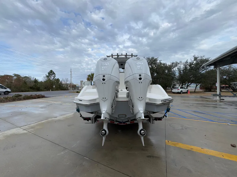 Slide: The Image of 2025 Solace 28 HCS boat with dual outboard engines on a concrete lot. - 19