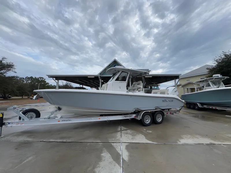Slide: The Image of 2025 Solace 28 HCS boat on trailer under cloudy sky. - 2