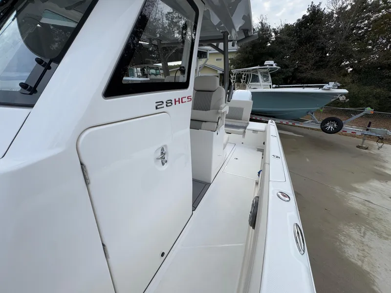 Slide: The Image of 2025 Solace 28 HCS boat, white exterior, docked with another boat in the background. - 29