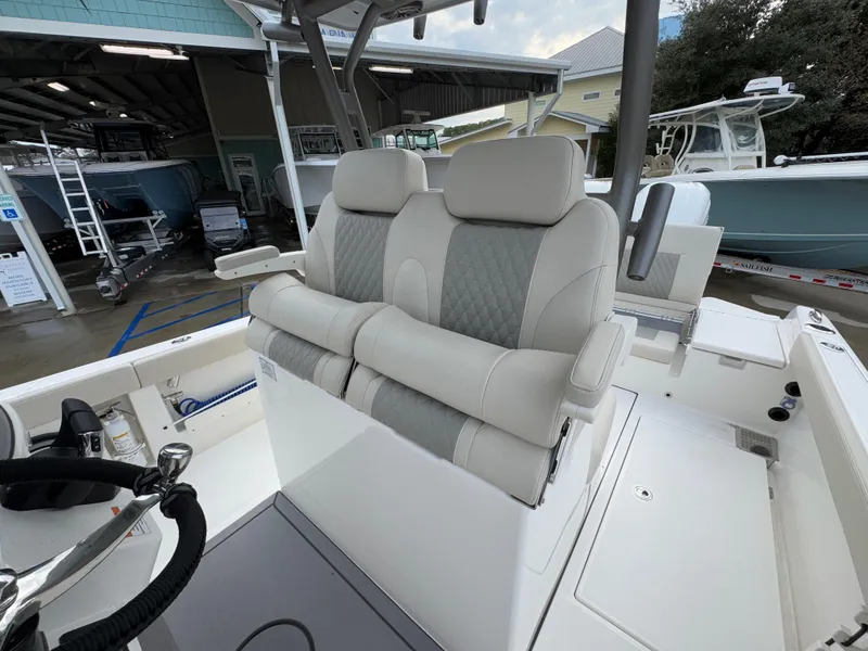 Slide: The Image of 2025 Solace 28 HCS boat with dual cushioned seats and modern helm station. - 35