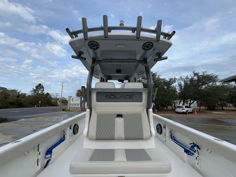 Slide: The Image of 2025 Solace 28 HCS boat interior with seating and overhead speakers, under a cloudy sky. - 41