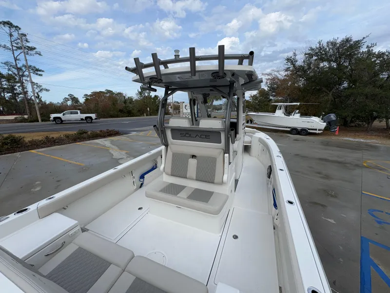 Slide: The Image of 2025 Solace 28 HCS boat with sleek design, parked outdoors under cloudy sky. - 46