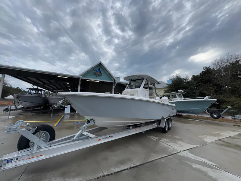 Slide: The Image of 2025 Solace 28 HCS boat on trailer under cloudy sky at dealership. - 5