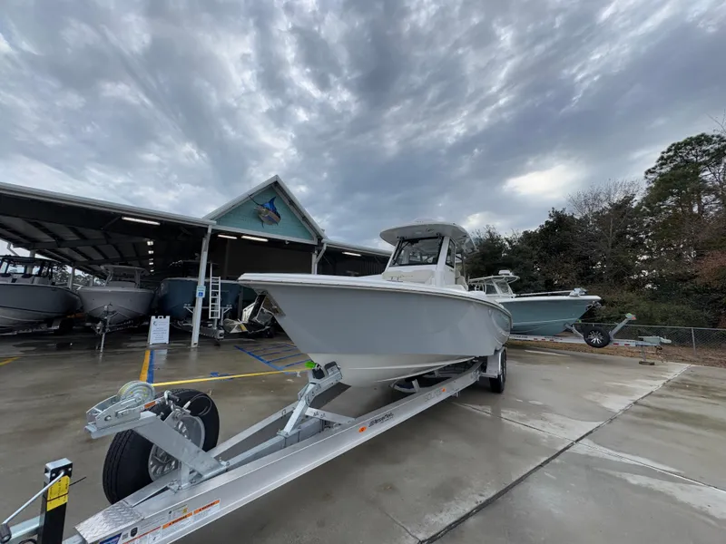 Slide: The Image of 2025 Solace 28 HCS boat on trailer under cloudy sky at dealership. - 6