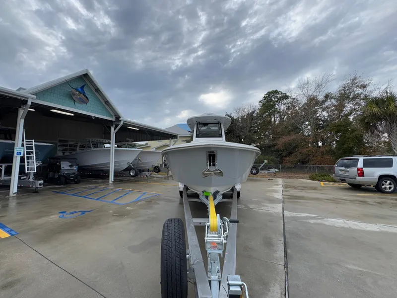 Slide: The Image of 2025 Solace 28 HCS boat on trailer at dealership, cloudy sky background. - 8