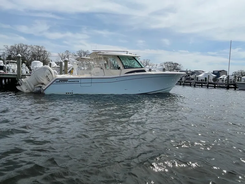 Slide: The Image of 2025 Grady-White Canyon 386 boat docked on calm water under a cloudy sky. - 10