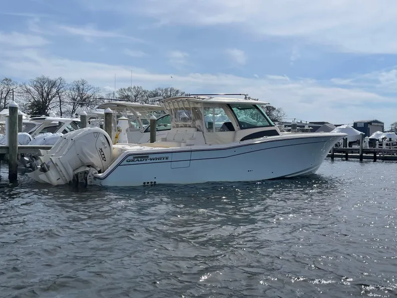 Slide: The Image of 2025 Grady-White Canyon 386 boat docked in a marina under a clear sky. - 11