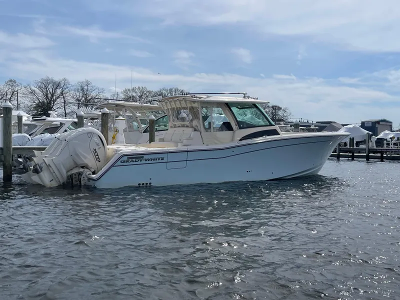 Slide: The Image of 2025 Grady-White Canyon 386 boat docked in a marina under a cloudy sky. - 12