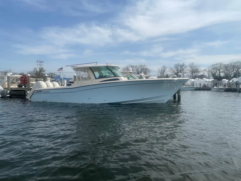Slide: The Image of 2025 Grady-White Canyon 386 boat docked on calm water under a clear sky. - 15